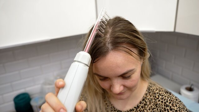 Trichologist using a darsonval comb for hair stimulation