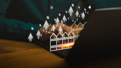 Real estate market growth concept showing person using laptop with rising commercial building...