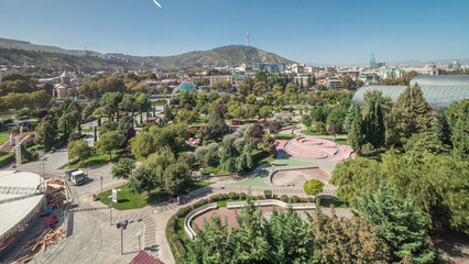 Aerial timelapse of Rike Park, a modern urban park in Tbilisi's Old Town with green trees and lawns. The Bridge of Peace in the background. Georgia © HyperlapsePro