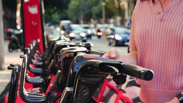 A resident of a European city rents a bike to ride on the weekend or to get to work uses a convenient mobile application. High quality 4k footage