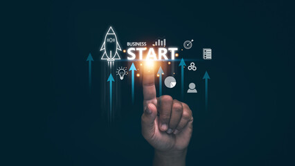 Business startup concept. Hand pointing to glowing START text with rocket icon and upward arrows....