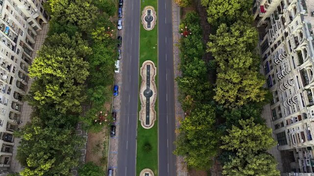 View of Unirii Boulevard lined with trees and cars. Bucharest.