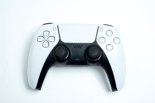 Modern white and black wireless gaming controller for a console on a white background. Playing interactive games on a console