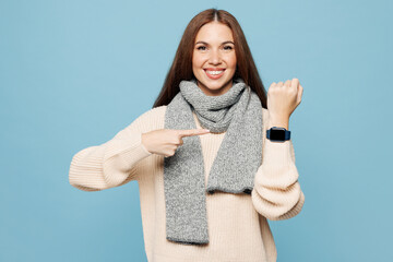 Young woman wear sweater scarf show use blank screen smartwatch to monitor health while fell unwell isolated on plain blue background. Healthy lifestyle ill sick disease treatment cold season concept.