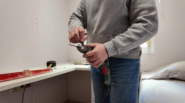 Handyman changing the drill bit on an electric power tool