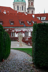 Historic stone statue in autumn garden with ivy-covered wall