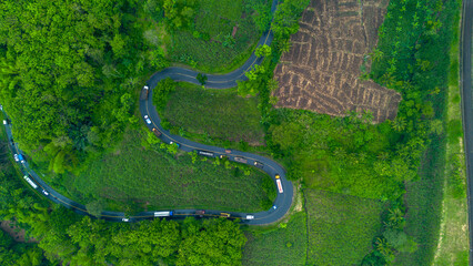 Aerial view of winding road in Malang, East Java, Indonesia surrounded by tropical green hills
