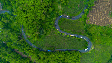 Aerial view of winding road in Malang, East Java, Indonesia surrounded by tropical green hills