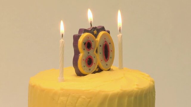 Elegant 80th birthday cake with golden accents and delicate frosting, serving as a sophisticated milestone celebration centerpiece.