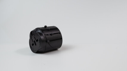Universal travel adapter in black against white background