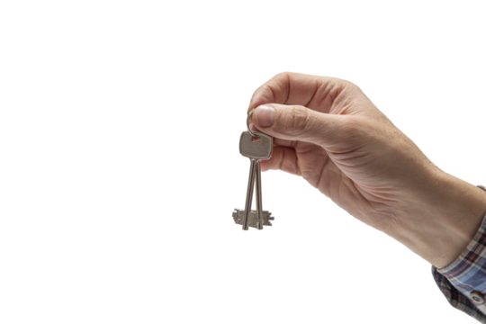 Hand of man in a checkered shirt holding keys on isolated background. Concept of sale of real estate, rent of housing