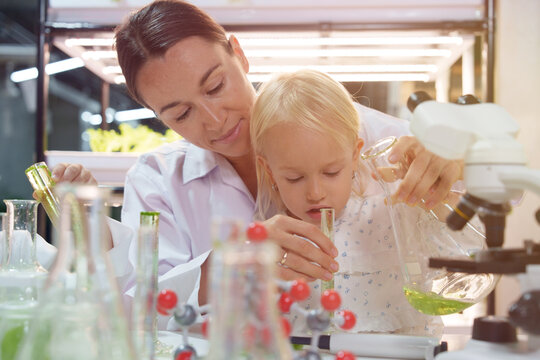 Cute school boy playing with molecular toys in laboratory classroom.	
