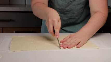 Hands cutting dough evenly on table surface, dough preparation showing precision and calm focus, dough process ideal for baking, homemade, or recipe stock footage.