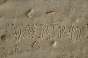 Word VACATION Written in Sand with Shells and Coral Pieces