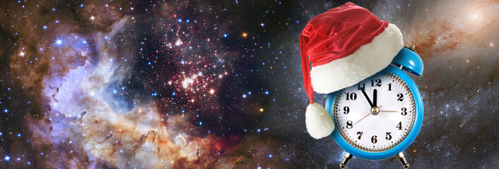 Clock wearing Santa hat spins in a galaxy filled with stars and vibrant colors during the festive...