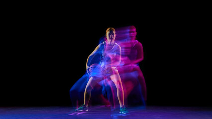 Female basketball player controlling ball under neon motion lights. Concept of motion technique analysis, balance improvement visuals, content for sports education and fitness brands.