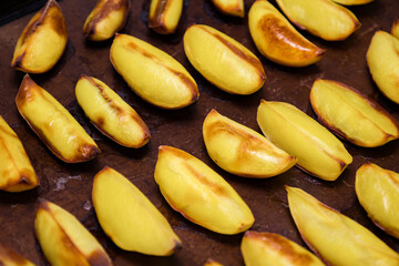 Freshly roasted yellow potatoes golden brown and crispy on a baking tray, perfect for side dishes or snacks