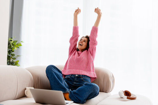 Happy woman celebrating remote work success at home - Powered by Adobe