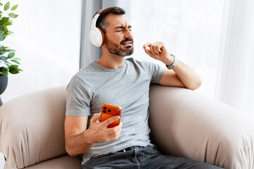 Man enjoying music listening on headphones with smartphone