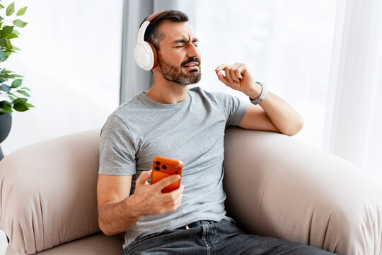 Man enjoying music listening on headphones with smartphone