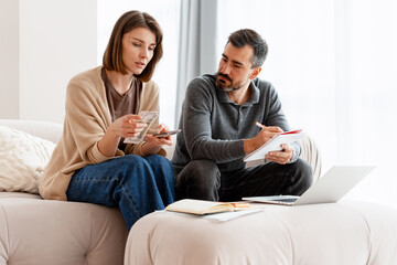 Couple managing home budget calculating finances and expenses
