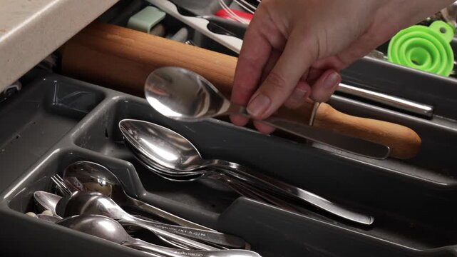 Human hand creating order among shiny metal tools, order gesture showing mindfulness and neat lifestyle, order moment perfect for household or cleaning concepts.