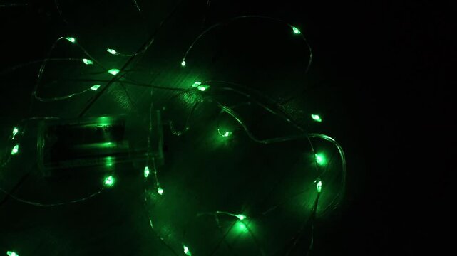 Abstract green bokeh lights gently shimmering on a dark background. Technology, festive, or nature concept. Green Christmas Bokeh. Festive holiday or St. Patrick's Day abstract lights background.