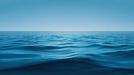 Obraz premium Tranquil Blue Ocean Surface with Gentle Waves Under Clear Sky, Ideal for Relaxation, Nature Scenes, and Inspirational Themes