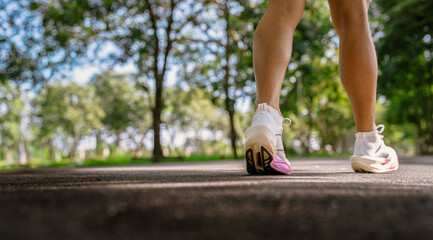 Runner starting jogging in park wearing white running shoes