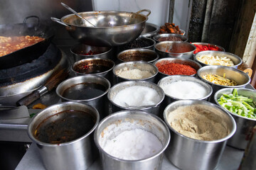 Spice counter with assorted seasonings and chopped vegetables, vibrant cooking ingredients ready for meal preparation and flavorful street food