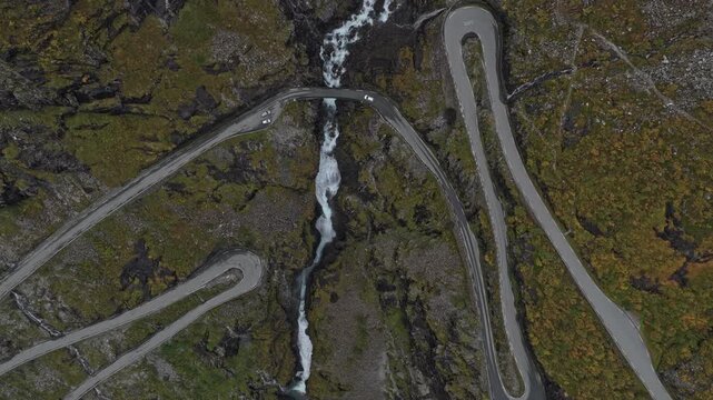 Aerial look at Trollstigen road as vehicles travel steep curves