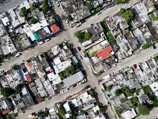 Aerial top-down view high altitude of slum a heavily populated urban informal settlement characterized by substandard housing and squalor poor living conditions streets and rusty metal home roof tops