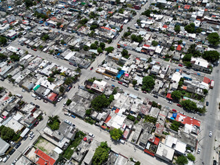 Aerial top-down view high altitude of slum a heavily populated urban informal settlement characterized by substandard housing and squalor poor living conditions streets and rusty metal home roof tops