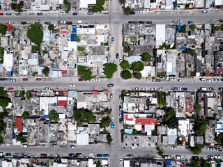 Aerial top-down view high altitude of slum a heavily populated urban informal settlement characterized by substandard housing and squalor poor living conditions streets and rusty metal home roof tops