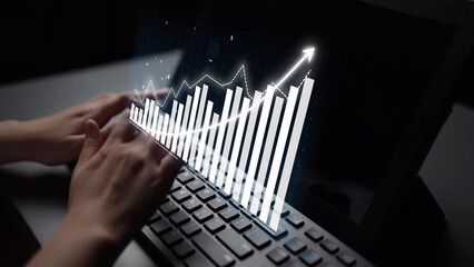 Hands are typing on a laptop keyboard, enhanced with a creative financial chart on the screen, illustrating growth trends in a professional workspace. Copula