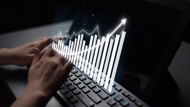 Hands are typing on a laptop keyboard, enhanced with a creative financial chart on the screen, illustrating growth trends in a professional workspace. Copula