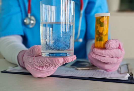 Healthcare professional presents glass of water and prescription medication concept