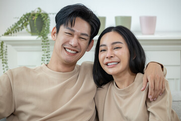 Happy couple laughing on the sofa and watching TV drama online