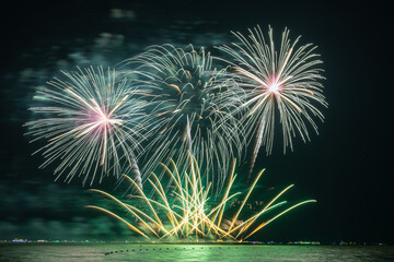 Multicolored Fireworks Exploding Over Water