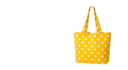 Bright yellow fabric tote bag with a white polka dot pattern hanging against a solid black background