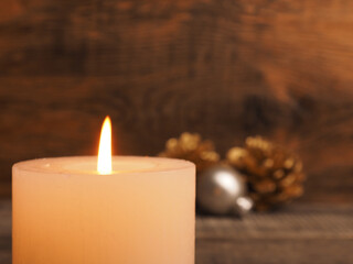 First Advent candle burning with Christmas decoration on wooden background