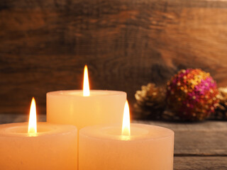 Third Advent candles burning with Christmas decoration on a wooden background