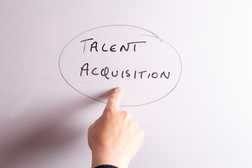 An HR business professional is pointing to the phrase Talent Acquisition on a whiteboard ideal for HR, recruitment, and business workplace presentations.
