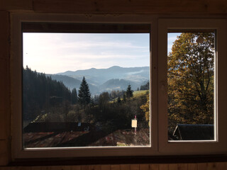 Beautiful amazing natural landscape in the mountains of Ukraine. Travel the world, discover wild locations. Protect the environment movement. Mountain view through the wooden window of ethnic house.