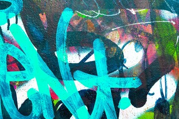 Vibrant graffiti art featuring teal, neon colors. Modern 2000s, urban style, bold strokes, dynamic texture. Murals, street art, creative design, urban visuals.