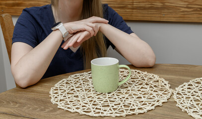 A lonely woman spends time at a table waiting for a social gathering or a date.