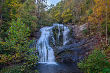 Obraz premium Bald River Falls flows peacefully through vibrant autumn trees near Tellico Plains in East Tennessee during a sunny day