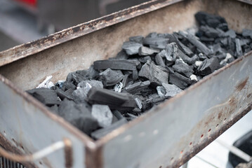 Burning charcoal embers in an outdoor metal brazier