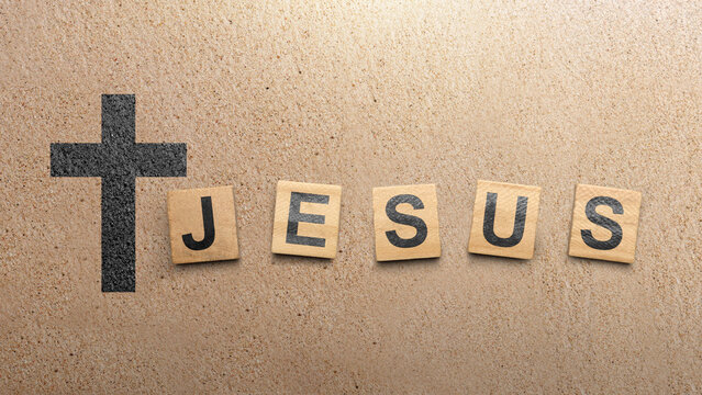 Christian cross and wooden cubes with Jesus text on a brown background. Concept of Christianity, religious, faith, Jesus, or belief - Powered by Adobe