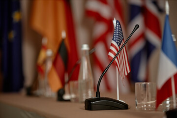 Conference table displaying national flags including United States, Germany, France, United...
